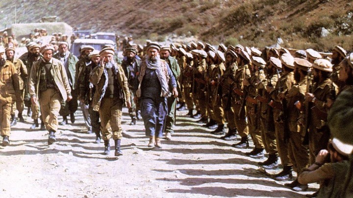 Abdallah Azzam walks down a road in Afghanistan.