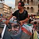 A protester hits a poster of Qassem Soleimani during ongoing anti-government protests in Baghdad in November 2019.