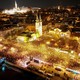 A drone view of a large crowd gathering to celebrate alongside the River Danube in Budapest, at night.