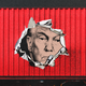 An illustration of Donald Trump's face showing from the ripped side of a shipping container