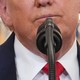 A close-up of Trump's face in front of a microphone, from the nose down