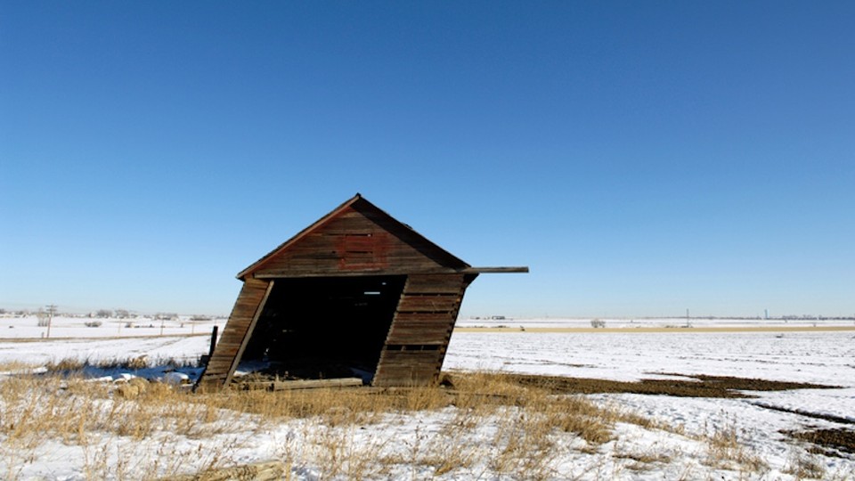 tilted wooden shack against blue sky
