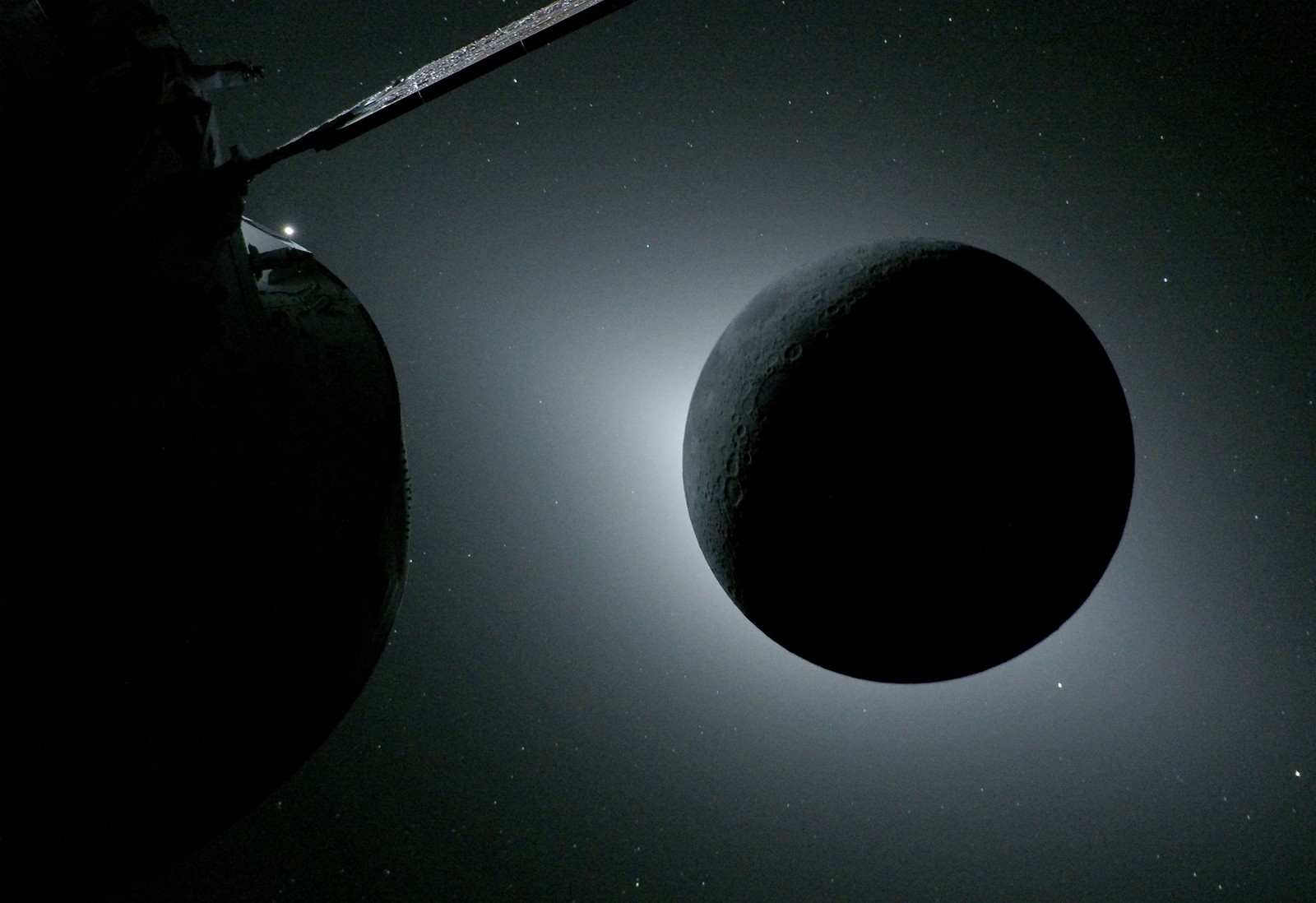 The moon, backlit by the sun during a solar eclipse, as seen from a spacecraft far from Earth.