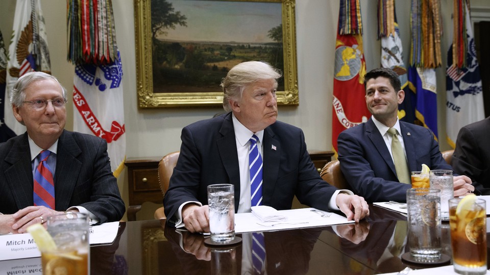 President Trump sits at a table with Paul Ryan and Mitch McConnell