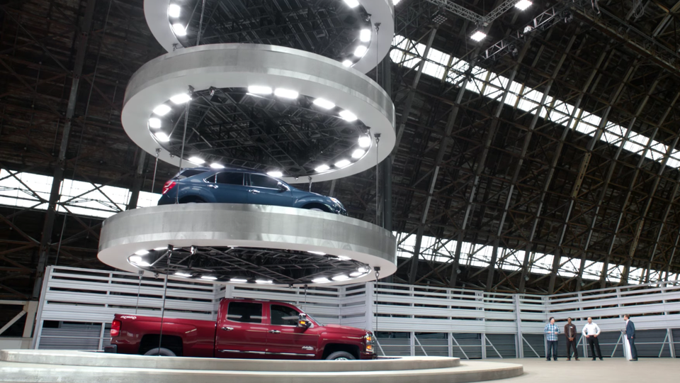 Cars on a large elevator as seen in a Chevrolet commercial