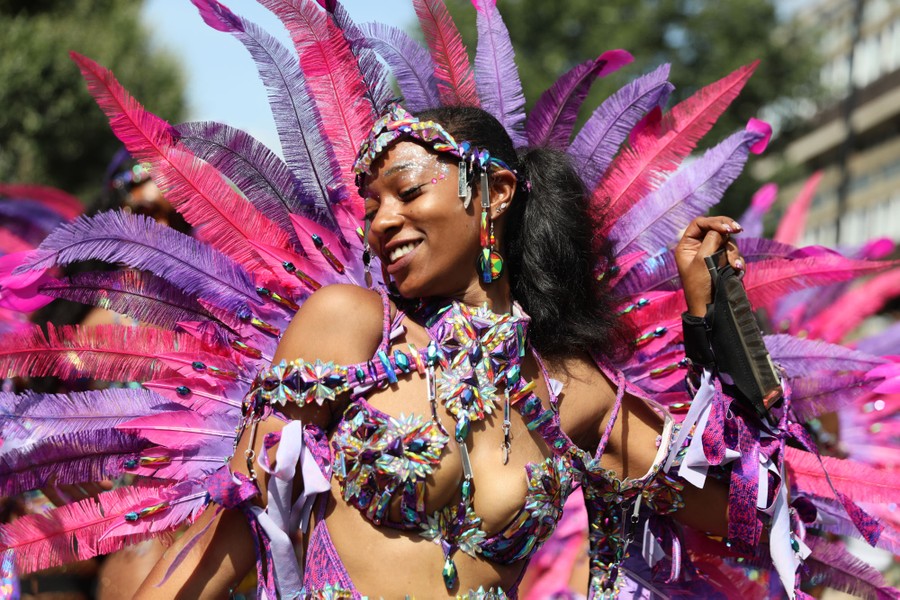 A dancer performs while wearing a colorful feathered costume.