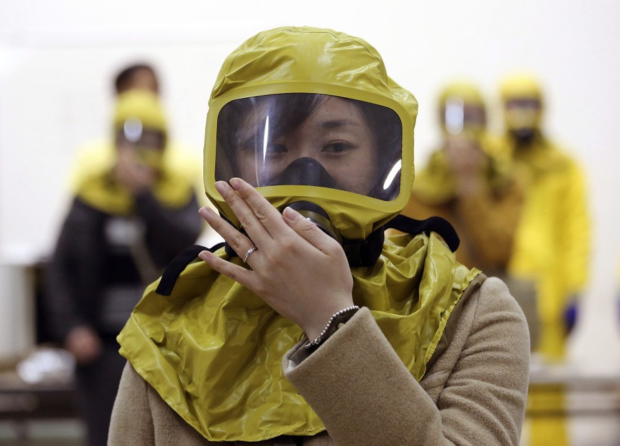 A South Korean government official checks her gas mask during a civil defense drill against possible North Korea's chemical attack at their office in Seoul, South Korea, on March 15, 2017.
