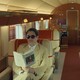 A color still from "The Phoenician Scheme" showing Benicio del Toro and Mia Threapleton in an airplane