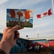 A photo of a Canadian postcard being held up next to a Canadian flag