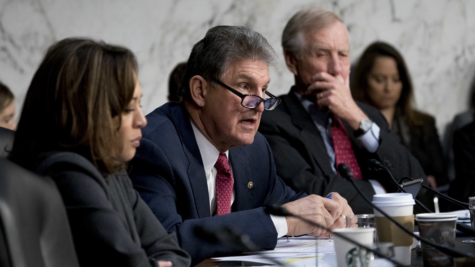 Senator Joe Manchin of West Virginia asks a question at a March 2018 Senate committee meeting. He is flanked by Senator Kamala Harris of California and Senator Angus King of Maine.