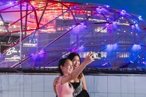 Two women take a selfie in front of the Intuit Dome.