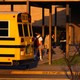 Students get off a school bus.
