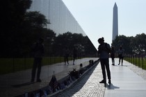 A photograph of a silhouette of a person observing the Vietnam Veteran's Memorial in Washington, D.C.