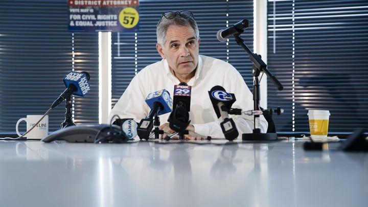 Larry Krasner, the Democratic candidate for district attorney in Philadelphia, sits at a table and speaks into multiple microphones during a news conference in May.