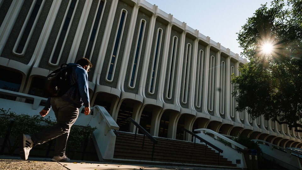 A man walks past Langson Library, at UC Irvine.