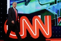 Donald Trump in front of the CNN logo