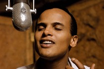 A young Harry Belafonte singing into a microphone