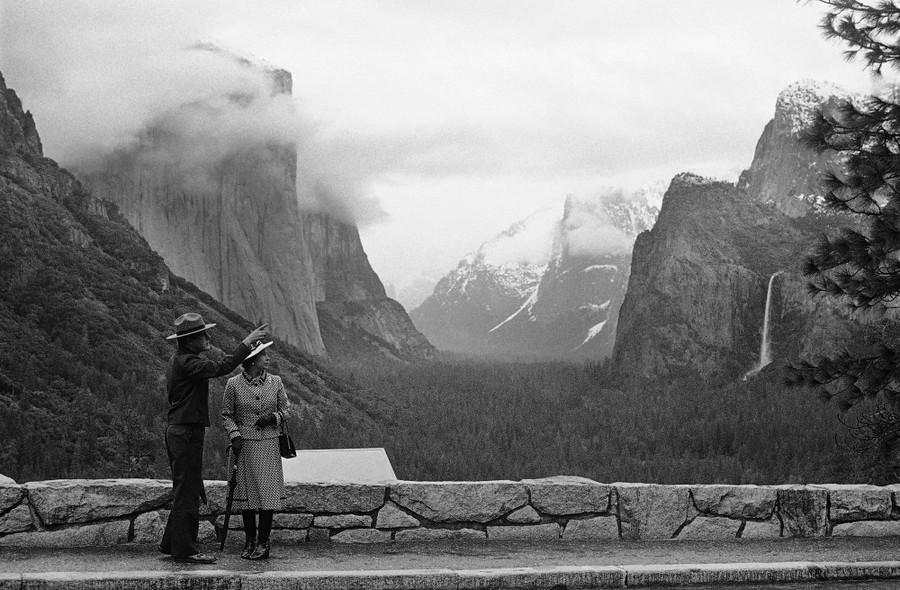 A parks-department worker speaks with the Queen in front of a beautiful valley in Yosemite National Park.