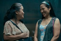 Two domestic helpers chat to each other in an elevator in the TV show 'Expats'