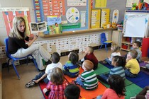 A teacher reads to sitting schoolchildren