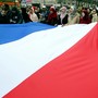 Women wearing head scarves carry the French national flag during a demonstration.