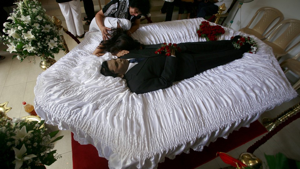 Ahimsha Wickrematunge (R), daughter of slain newspaper editor Lasantha Wickrematunga, mourns over his body at his residence in Colombo, Sri Lanka, January 11, 2009