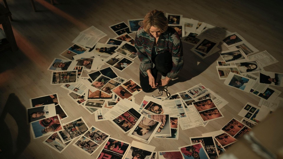 Detective Liz Danvers in True Detective looks at splayed out pictures of crime scenes