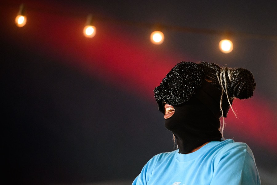 An artist performs while wearing a fabric mask.