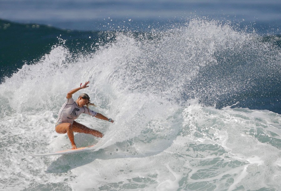A surfer rides a wave during a surfing contest.
