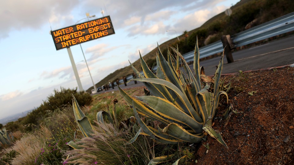 A highway sign that reads, "water rationing started—expect interruptions"