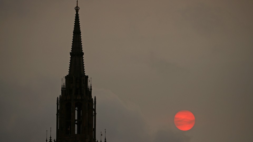 The sun sets behind the Houses of Parliament in London on October 16, 2017.