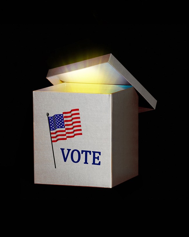 A white ballot box with the American flag above the word "vote"