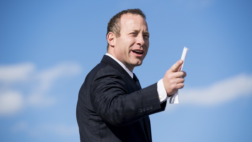 Josh Gottheimer holds a piece of paper and seems to point to something in the distance.