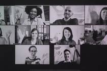 A black-and-white image of a group video call with people waving in each square