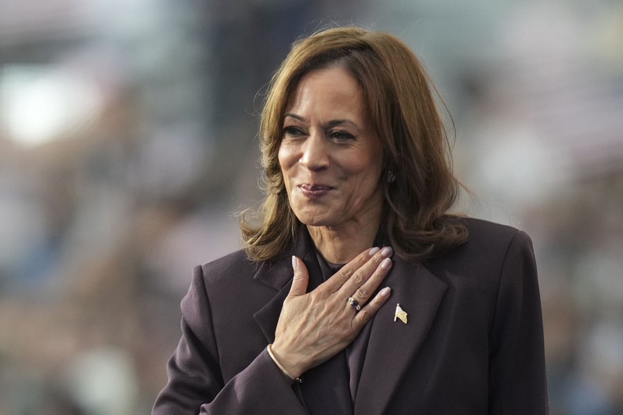 Kamala Harris gestures to a crowd, holding her hand to her chest.