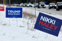 Campaign signs for Donald Trump and Nikki Haley stand in the snow in Loudon, New Hampshire