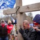 Supporters of President Donald Trump pray outside the U.S. Capitol on January 6, leaning on a large wooden cross.