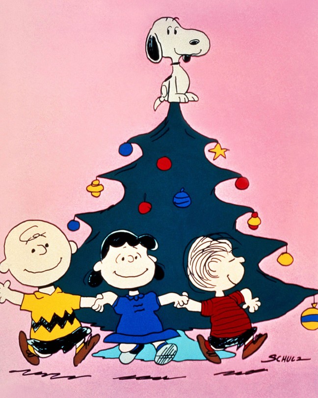A still from A Charlie Brown Christmas showing Snoopy on top of a Christmas Tree as other characters dance below