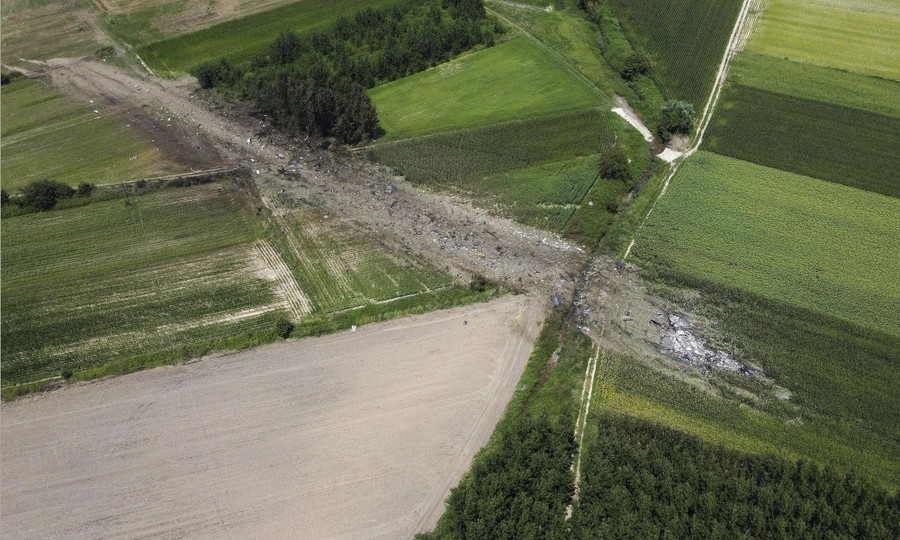 A broad swath of debris lies across several farm fields, wreckage of a crashed cargo plane.