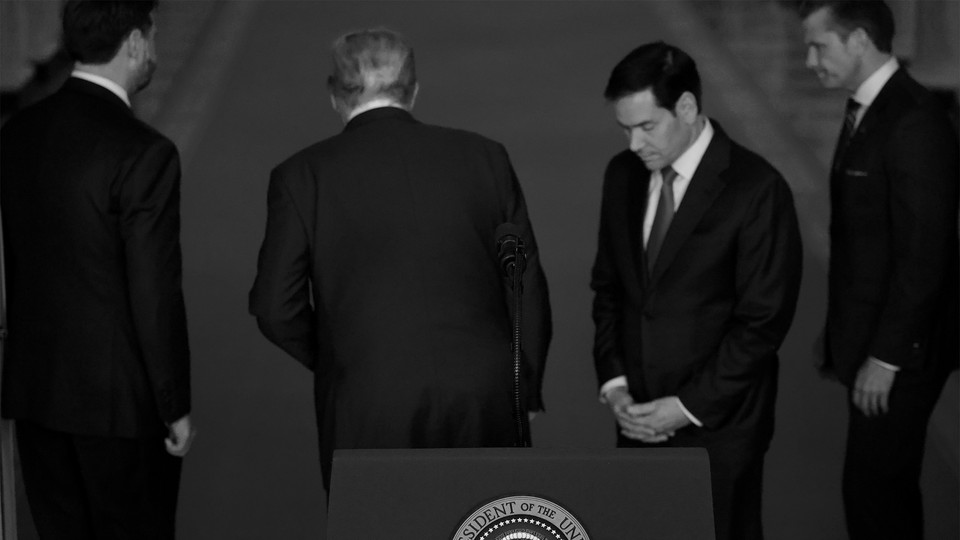 Donald Trump flanked by aides at a press conference