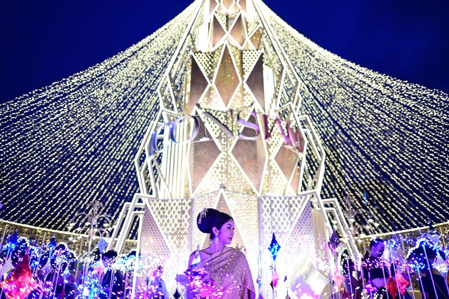 A woman poses amid a light installation.