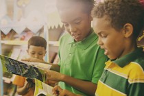 Young children perusing books at a Scholastic book fair