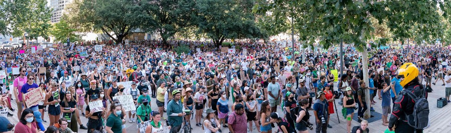 A wide view of a large crowd of protesters gathered in a plaza