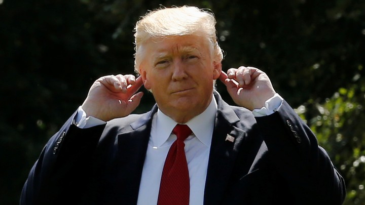 Donald Trump motions to his ears.