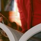 closeup of a person's hands holding an open paperback book