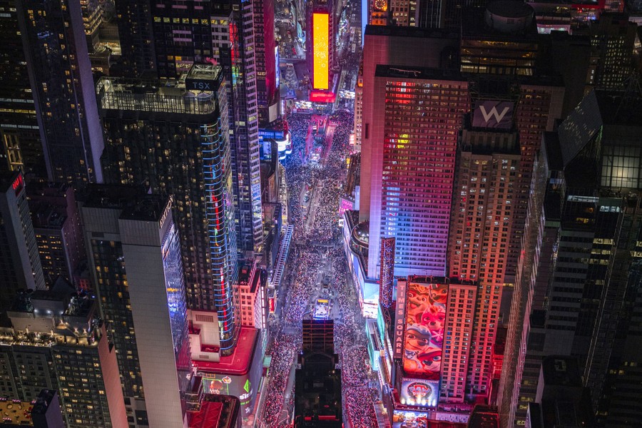 An aerial view of a brightly lit Times Square filled with people