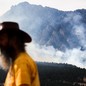 A man watches as the NCAR Fire burns on March 26, 2022 in Boulder, Colorado.