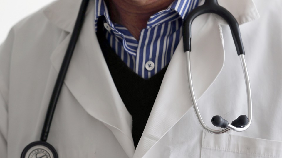 A photo-illustration shows a French general practitioner with a stethoscope in a doctor's office in 2015.
