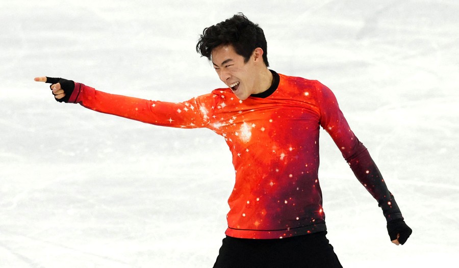 A figure skater stands and points, during a performance.