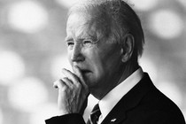 A picture of Joe Biden with his hand in front of his mouth